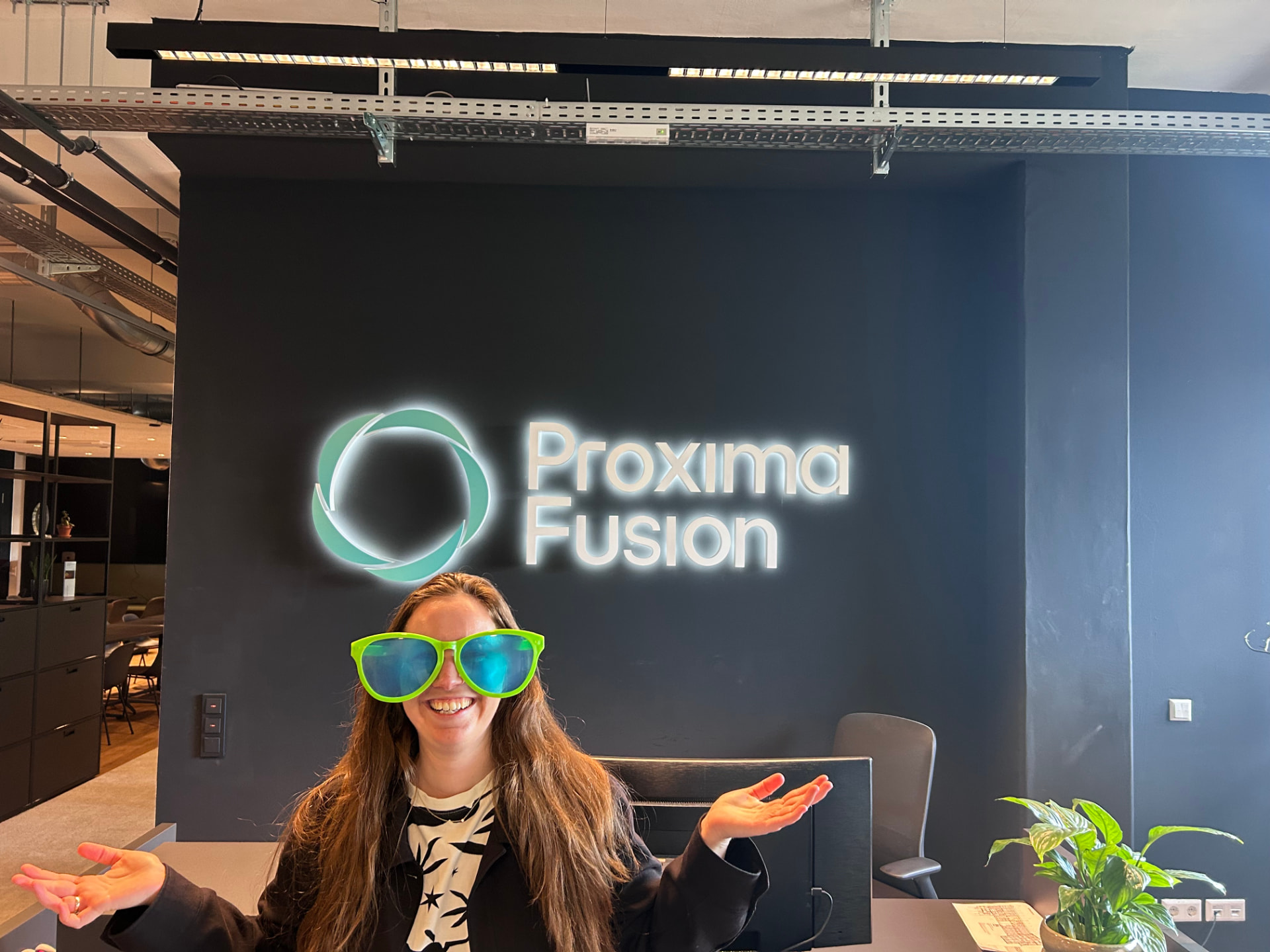 Vera smiling in oversized neon green glasses at Proxima Fusion