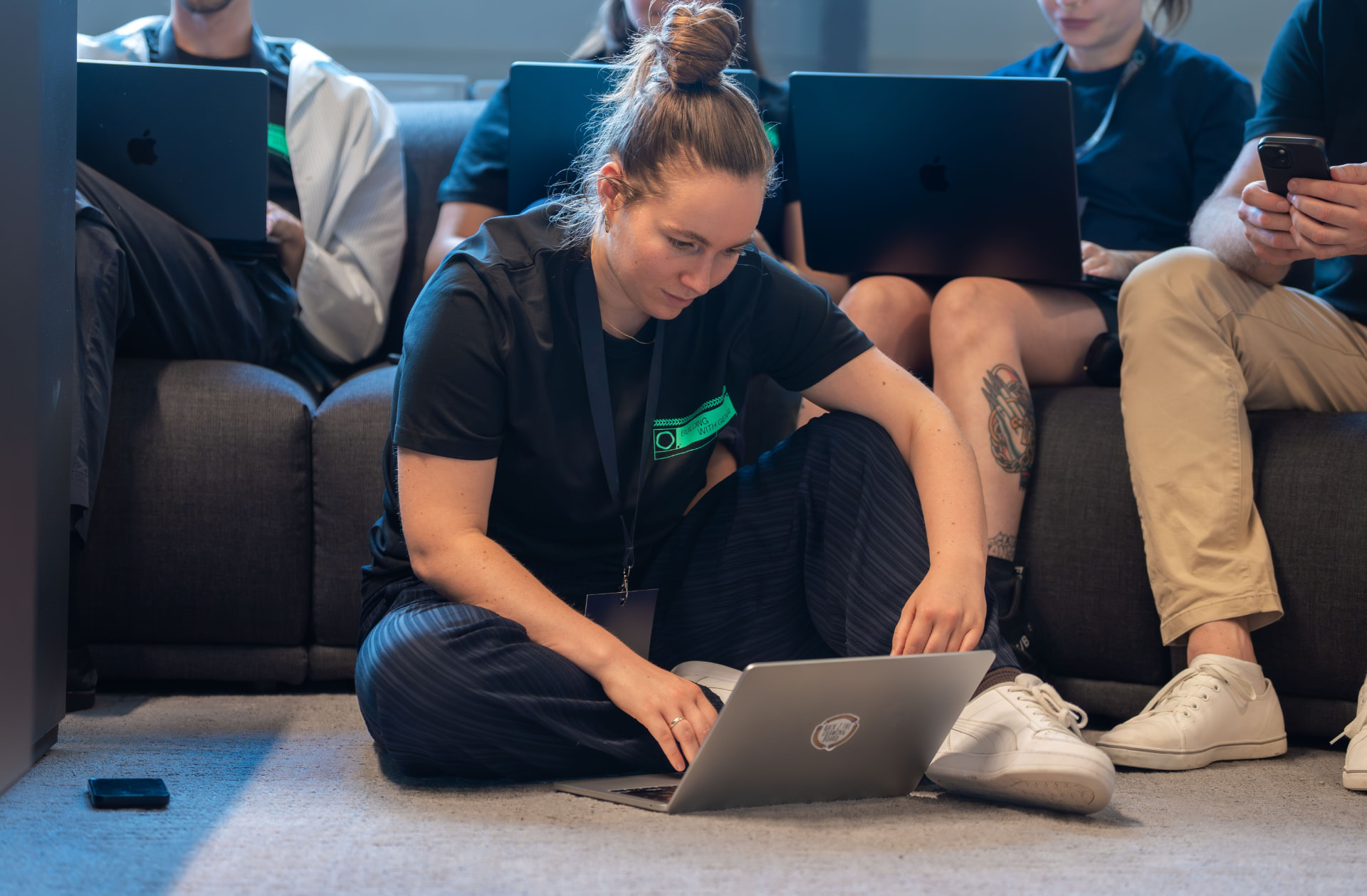 Vera working on a laptop on the floor during a hackathon